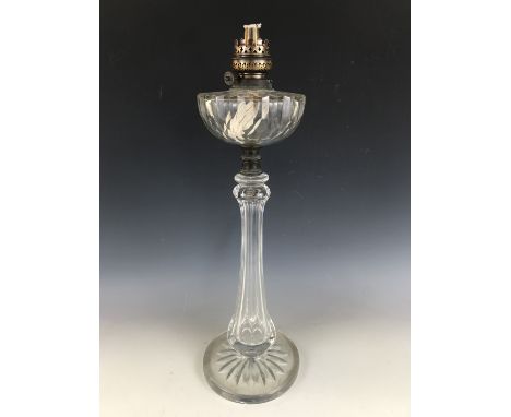 A late Victorian cut glass oil lamp, the reservoir supported on a faceted hollow-blown baluster column with star-cut base, 62