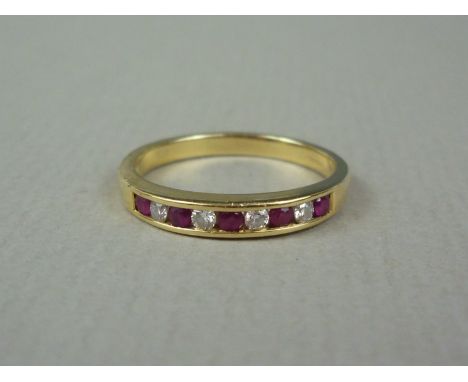 An 18ct gold ruby and diamond dress ring, the face channel set in an alternating arrangement of captive brilliant cut diamond