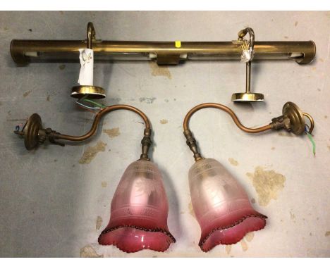 Group of brass picture lights and a pair of light fittings with cranberry glass shades