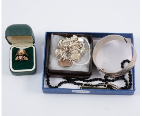 A silver solid half hinged bangle, 15mm wide with diamond cut engraving, hallmarked 1979, a silver charm bracelet with eleven
