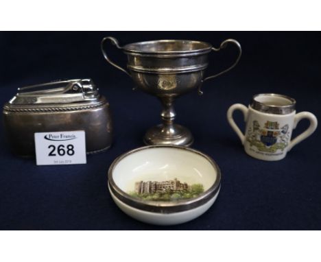 A miniature silver two handled trophy cup, together with a silver plated table lighter, miniature ceramic two handled mug wit