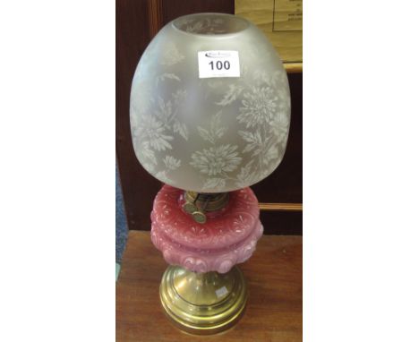 Early 20th Century brass double burner oil lamp with pink relief glass reservoir, brass pedestal base, etched glass shade and