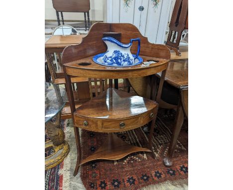 A George III mahogany bow front three tier corner washstand, width 58cm, depth 38cm, height  99cm with an associated jug and 