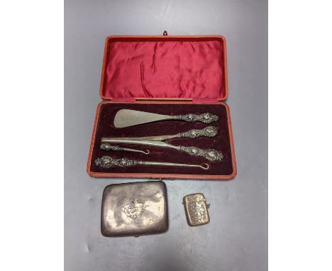 A George V silver cigarette case, an earlier silver vest case and a cased set of button hooks, shoe horn and glove stretchers