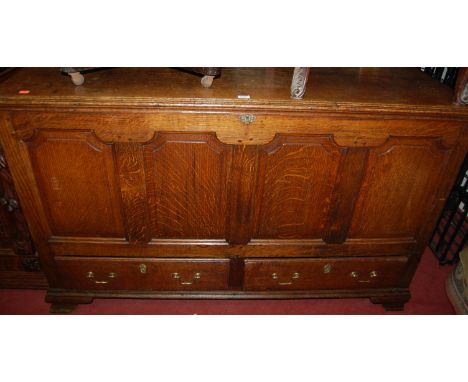 An early 18th century joined oak four panel hinged top mule chest, with twin lower drawers 