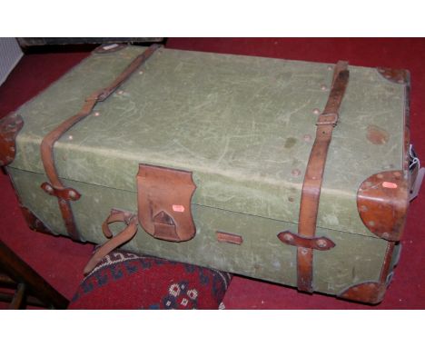 An early 20th century canvas and tan leather bound travelling trunk having end carry handles