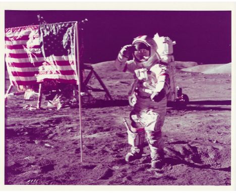 Harrison SchmittMission Commander and the last person to walk on the Moon, Eugene Cernan, salutes while standing by the US fl