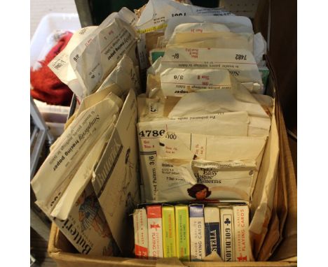 A small box containing a selection of vintage sewing patterns and playing cards