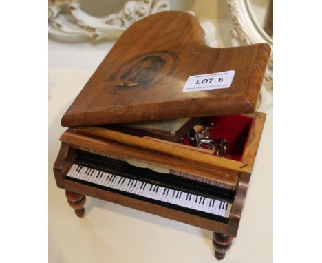 A treen wooden musical&nbsp;jewellery box fashioned in the shape of a grand piano containing a small selection of costume jew