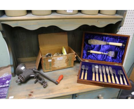 A cased set of fish knives and forks with two vintage spong style mincers