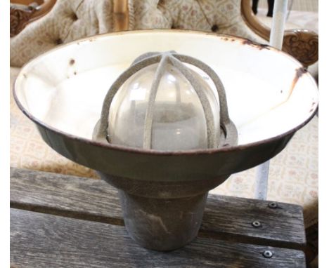 A vintage industrial light fitting in explosion proof cage
