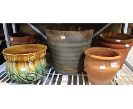 A shelf containing a selection of terracotta and glazed pot planters