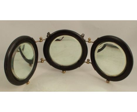 A travelling folding tryptic mirror, the three circular wooden framed mirrors having bevelled plates, with gilt metal hinges 