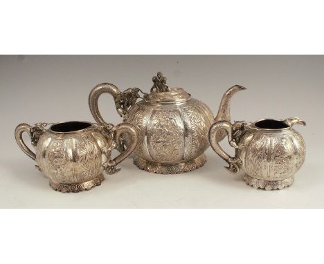 A late 19th century Chinese Export silver three piece tea set, comprising teapot, milk jug and sugar bowl, each with dragon h