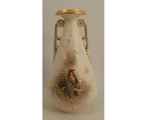 A Grainger &amp; Co Worcester ivory vase, with pierced twin handles, decorated with a bird seated on a gilt branch with folia