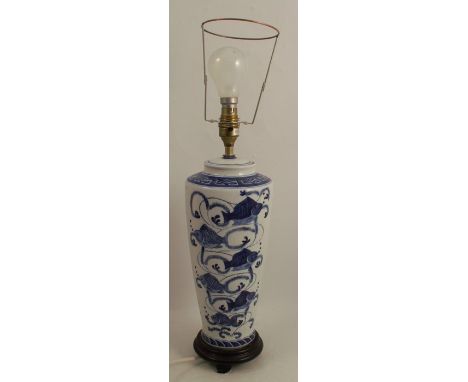 A porcelain table lamp, decorated in blue and white with Oriental fish, on a wooden base, height 14ins