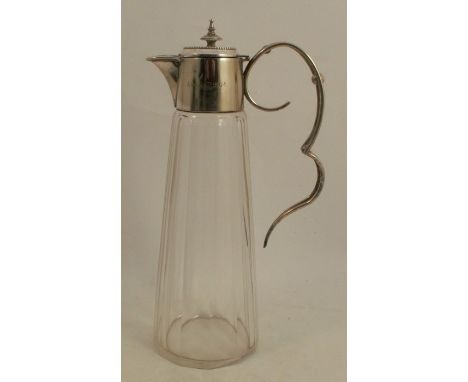 A silver plated and glass claret jug, the silver plated mount engraved with a date and initials, with open wire works scroll 