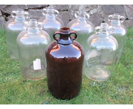 Seven various glass demi johns, together with a grey enamel lamp shade