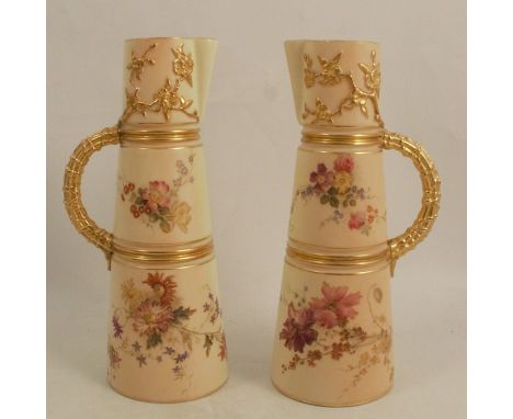 A pair of Royal Worcester blush ivory claret jugs, decorated with floral sprays and having gilt moulded handles, shape number