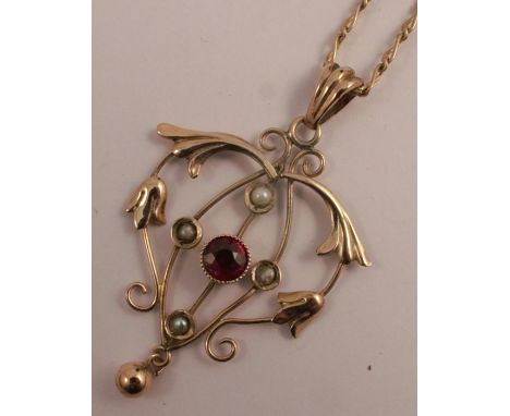 A 9 carat gold seed pearl and garnet pendant, the filigree pendant set with four seed pearls and a brilliant cut garnet to th