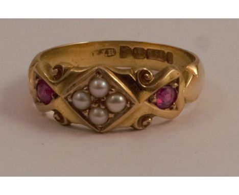 A 15 carat gold seed pearl and ruby ring, the four pearls set in a diamond shape with a ruby to each side, hallmarked Chester