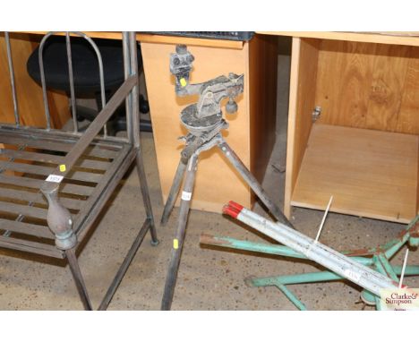 A vintage metal tripod with adjustable stand to the top