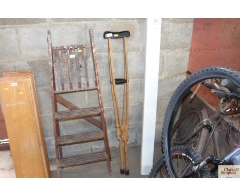 A pair of vintage wooden adjustable crutches