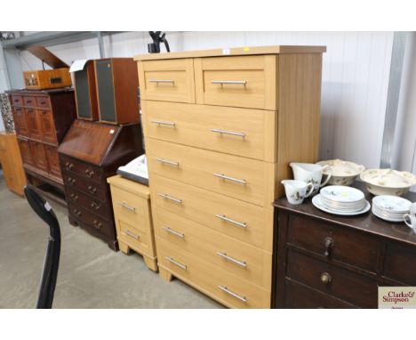 A light oak effect chest fitted two short over five long drawers together with a matching bedside chest fitted two drawers