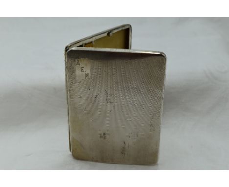 A white metal cigarette case stamped sterling silver having a slide clasp and engine turned decoration with date to interior 