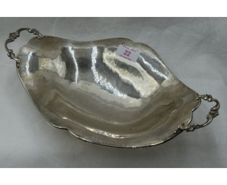 A white metal table bowl of shaped boat form having moulded handles, plannished finish and bracket feet, bearing mark to base