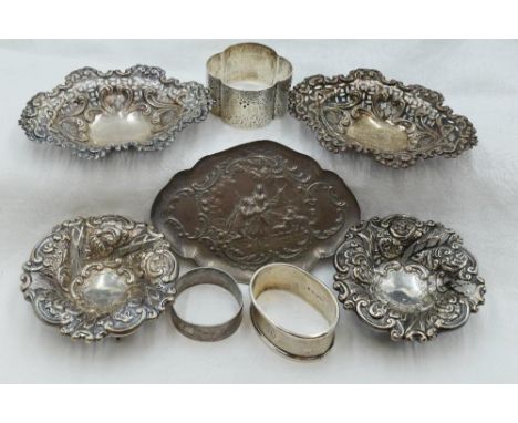 A selection of HM silver including an oval pin tray with moulded lovers scene, a pair of oval pin dishes with pierced decorat