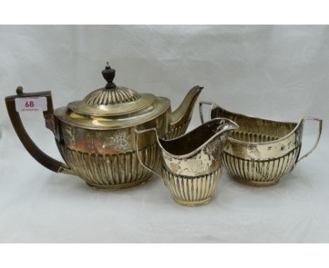 A Victorian silver three piece matched breakfast tea set of oval form having gadrooned decoration and monogram to side, Londo