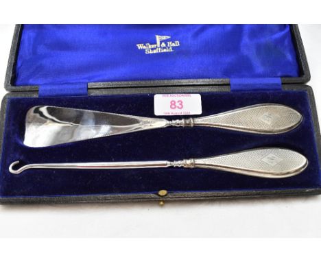A cased silver handled shoe horn and button hook having engine turned decoration and bearing monogram B to cartouche, Sheffie