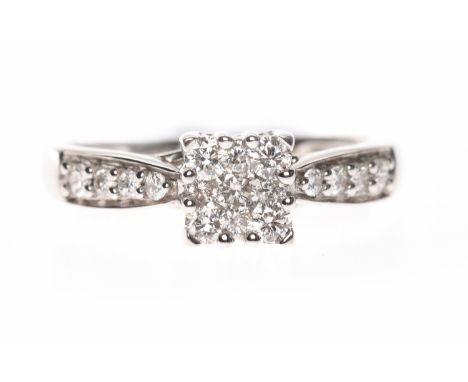 NINE CARAT WHITE GOLD DIAMOND CLUSTER RINGthe square bezel formed by round brilliant cut diamonds and on diamond set shoulder