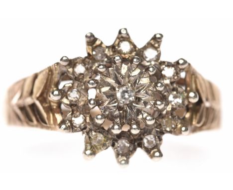 NINE CARAT GOLD DIAMOND CLUSTER RING1970s, the round bezel set with round diamonds, on engraved shoulders, size U, 5.5g