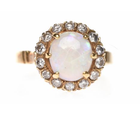 OPAL AND DIAMOND CLUSTER RINGset with a central oval cabochon cut opal surrounded by round diamonds, unmarked, size N-O