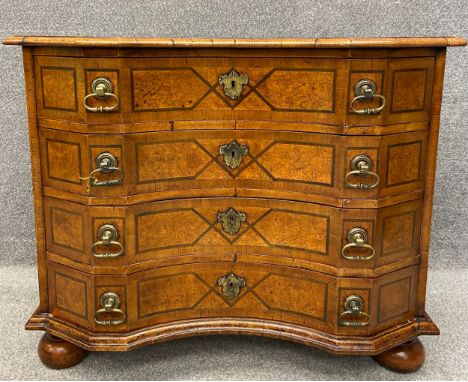 An 18th century Italian walnut commode chest with a quarter veneered and crossbanded top with thumb moulded edge, over four c