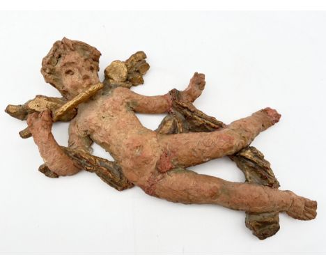 An indistinctly signed naive style painted ceramic figure of a cherub. L.34cm.