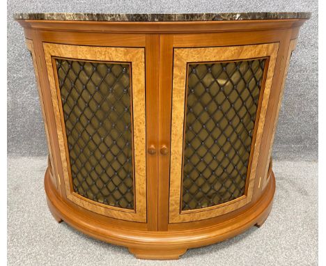 A contemporary walnut and birdseye maple demi-lune console table or radiator cabinet with metal latticework doors and a marbl