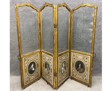 A 19th century glazed and gilded four panelled dressing screen; each panel having a carved and shaped frame above a lower sec