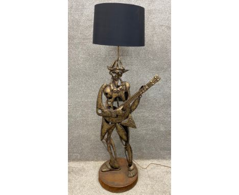A Spanish folk art style figural hammered and applied steel floor lamp with shade. H.149cm.
