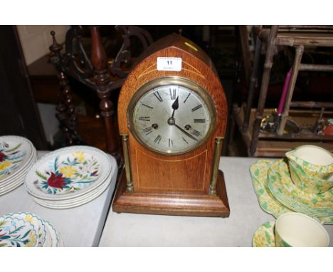 An early 20th Century oak cased and inlaid two hole mantel clock 