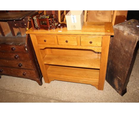 A modern light oak open fronted bookcase fitted three drawers above 