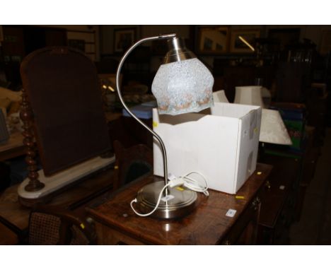 A metal desk lamp with mottled glass shade