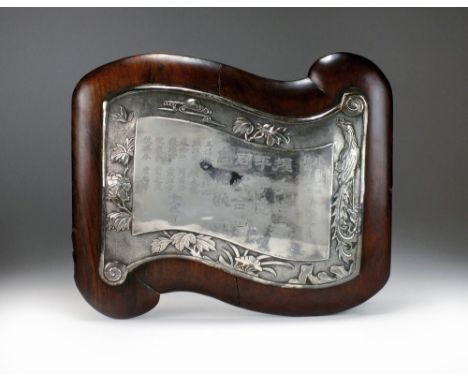 A Chinese silver plaque, Qing, circa 1900, formed as an open scroll, the border chased with a pheasant perched on a rock with