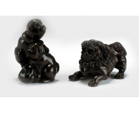 Two Japanese carved wood netsuke, 19th century, the first modelled as three puppies tumbling over each other, 5cm, the second