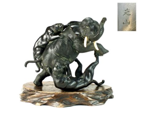 A Japanese bronze figure of an elephant attacked by tigers, Meiji period, the main figure raised on its hind legs with trunk 