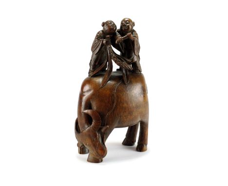 A Chinese bamboo carving of boys on a buffalo, Qing, possibly depicting Hehe Erxian, modelled standing astride the back of a 
