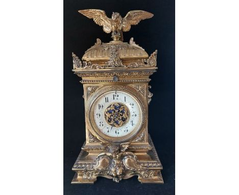 A French gilt brass mantel clock, late 19th, the enamel dial with Arabic numerals, the architectural case with putti, masks a