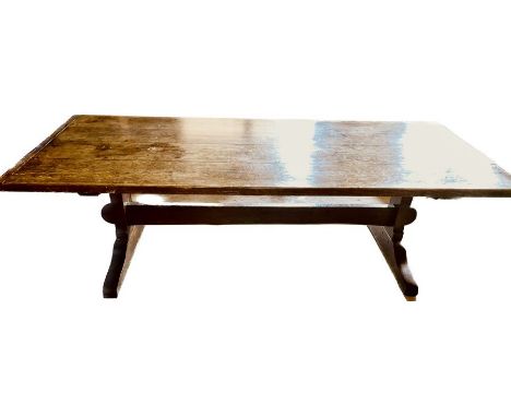 A George III oak trestle table, circa 1790, four plank top with cleated ends, raised on trestle feet, united by a pin joined 